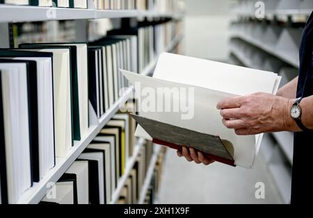 Berlin, Deutschland. Juli 2024. Nach Wasserschäden in der Zentral- und Landesbibliothek Berlin werden Blotting-Blätter in die Seiten eines beschädigten Buches eingefügt. Quelle: Britta Pedersen/dpa/Alamy Live News Stockfoto