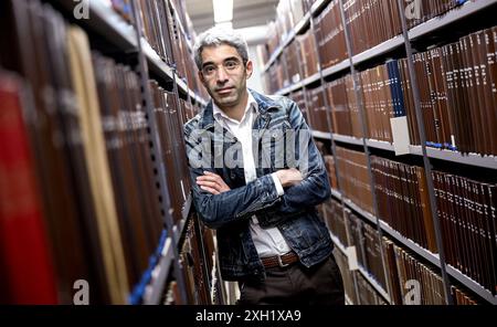 Berlin, Deutschland. Juli 2024. Jonas Fansa, Betriebsdirektor der Zentral- und Landesbibliothek Berlin, prüft nach Wasserschäden in einem Gebäude der Zentral- und Landesbibliothek die Bücher in den Regalen. Quelle: Britta Pedersen/dpa/Alamy Live News Stockfoto