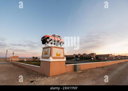 Einladungsdekoration am Eingang des Meteorites Hotels in Zaida, in der Region Meknes-Tafilalet in Marokko. Es ist ein altes rotes Auto, das auf dem montiert ist Stockfoto