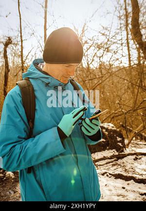 Ein Mann benutzt sein Handy im Wald Stockfoto