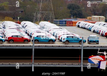 Schutzverkleidungen decken eine Lieferung von elektrischen SUVs des Typs Atto 3 in China ab, die in einem Fahrzeuglagerbereich gelagert werden und auf den britischen Vertrieb durch Kfz-Transporter warten. Stockfoto