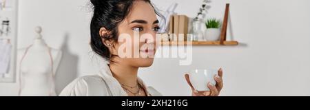 Eine stilvolle Frau hält ruhig eine dampfende Tasse Kaffee. Stockfoto