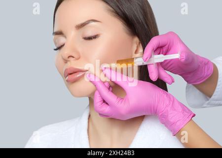 Kosmetikerin macht prp-Therapie gegen Falten und alternde Haut auf dem Gesicht einer schönen Frau in einem Schönheitssalon. Kosmetologiekonzept. Stockfoto