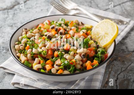 Salat von Mavromatika von Feneos mit schwarzäugigen Erbsen und Gemüse aus der Nähe auf dem Teller auf dem Tisch. Horizontal Stockfoto