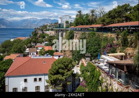 Ein malerischer Blick auf die Altstadt von Antalya mit roten Häusern, umgeben von Grün und dem Mittelmeer im Hintergrund, Türkei Stockfoto