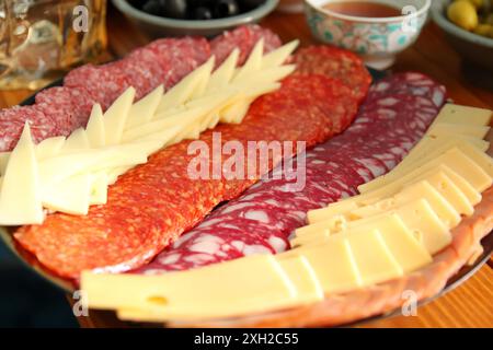 Antipasto-Platte mit Speck, Jerky, Salami, Käse-Nahaufnahme Hintergrund. Teller mit Wurst und Käse. Stockfoto