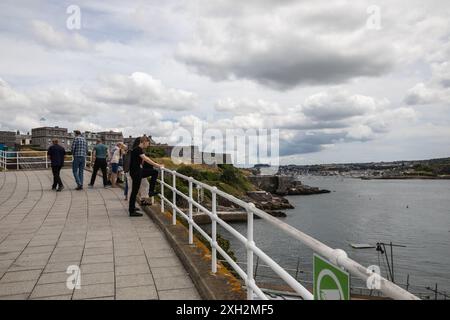 Plymouth, Devon, 11. Juli 2024, die Leute waren auf der Hoe in Plymouth, Devon, unterwegs. Mit einem unschlagbaren Blick auf den Plymouth Sound ist es der perfekte Ort, um einen Tag zu verbringen, ein Picknick auf dem Gras zu genießen oder ein Bad im Art déco-Tinner Lido zu nehmen. Der Smeaton's Tower ist ein Leuchtturm aus dem 18. Jahrhundert mit Blick auf den Plymouth Sound mit seinen berühmten roten und weißen Streifen. Quelle: Keith Larby/Alamy Live News Stockfoto
