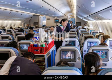 Kabinenbesatzung und Passagiere, die auf einem Flug von Bangkok nach Manila mit Philippine Airlines fliegen Stockfoto
