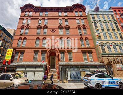 NYC Chinatown: Blick auf die 1 Elizabeth Street, ein sechsstöckiges Backsteinwohnhaus, rot gestrichen; Star of David Medaillon zeigt jüdische Abstammung. Stockfoto