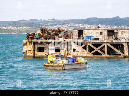 Alte und weggeworfene Booms, Fischernetze, Ketten, Bügel und Angelausrüstung auf einem stillgelegten Steg im Brixham Harbour Stockfoto