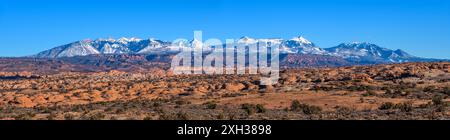 La Sal Mountains - Panorama der schneebedeckten La Sal Mountains, überragend über orange versteinerten Dünen und rotem Sandstein mesa. Arches National Park, UT, USA. Stockfoto