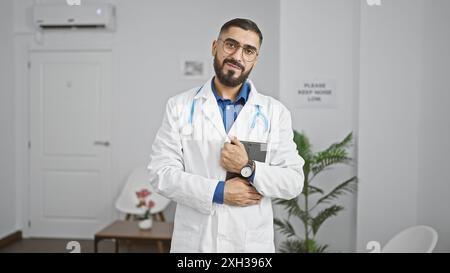Sicherer araber im medizinischen Mantel mit Stethoskop im Klinikkorridor Stockfoto