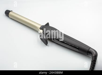 Elegantes Lockenbügeleisen für professionelles Styling mit modernem Design und fortschrittlicher Heiztechnologie. Nahaufnahme auf weiß. Stockfoto