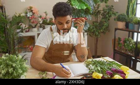 afroamerikaner planen in einem Blumenladen, umgeben von grünen Pflanzen und bunten Blumen Stockfoto