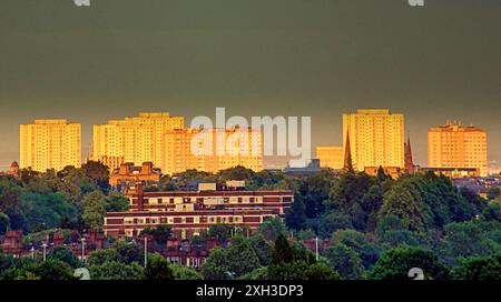 Glasgow, Schottland, Großbritannien. 11. Juli 2024: Wetter in Großbritannien: Der Sonnenuntergang wird rot über den Hochhäusern im Stadtzentrum vom grünen Westende der Stadt. Credit Gerard Ferry/Alamy Live News Stockfoto