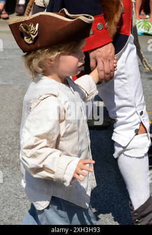 Ein Mann und sein Sohn, gekleidet in nachgebildeter Militärkleidung des 18. Jahrhunderts, nehmen an einer Parade am 4. Juli in Hendersonville, NC, Teil. Stockfoto