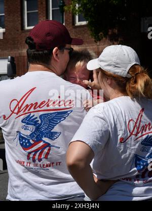 Ein Paar mit passenden „America Love IT or Leave IT“-T-Shirts sieht sich eine Parade am 4. Juli in Hendersonville, North Carolina, an. Stockfoto