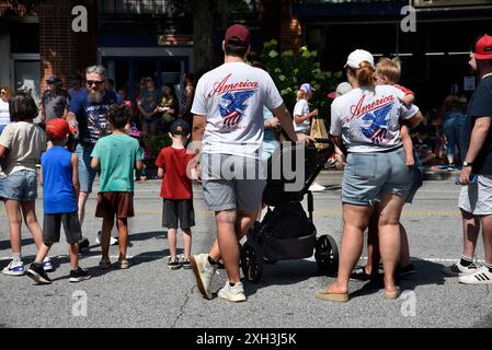 Ein Paar mit passenden „America Love IT or Leave IT“-T-Shirts sieht sich eine Parade am 4. Juli in Hendersonville, North Carolina, an. Stockfoto