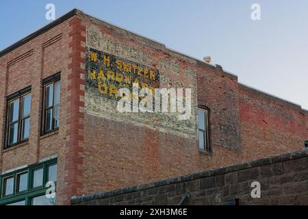 Übereinander verblasste Geisterschilder auf dem alten Backsteingebäude Stockfoto