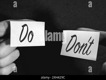 Zwei Haftnotizen auf schwarzem Hintergrund, mit Do's und Do's. Stockfoto