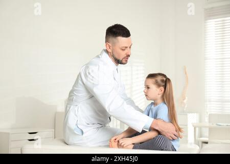 Professioneller Orthopäde untersucht kleines Mädchen in der Klinik Stockfoto