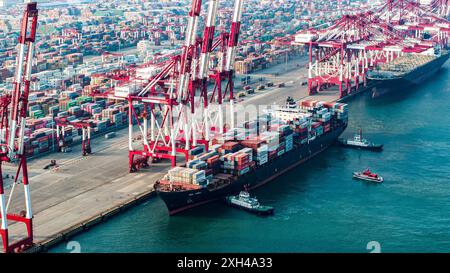 QINGDAO, CHINA - 11. Juli 2024 - Container werden am Qianwan Containerterminal des Hafens Qingdao, Hafen Shandong, China, 11. Juli, be- und entladen. Stockfoto