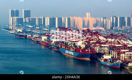 QINGDAO, CHINA - 11. Juli 2024 - Container werden am Qianwan Containerterminal des Hafens Qingdao, Hafen Shandong, China, 11. Juli, be- und entladen. Stockfoto