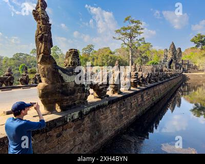 Die Brücke nach Angkor Thom, auf beiden Seiten mit Figuren gesäumt, die in einem gewölbten Eingang enden, Kambodscha. Stockfoto