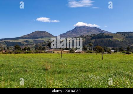 Der Vulkan Ilinizas, die Andenlandschaft mit ihren Feldern und Bergen, die ihr Grün an einem klaren Morgen zeigen, südöstliche Sicht. Stockfoto