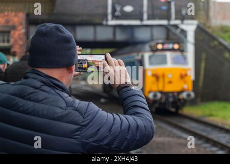 Eisenbahnliebhaber, der ein Handyfoto der erhaltenen Diesellokomotive der Baureihe 50 50017 an der Great Central Railway in Loughborough Station macht Stockfoto