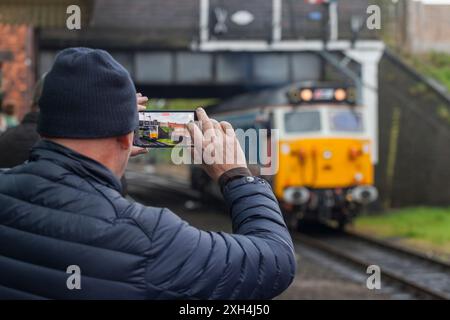 Eisenbahnliebhaber, der ein Handyfoto der erhaltenen Diesellokomotive der Baureihe 50 50017 an der Great Central Railway in Loughborough Station macht Stockfoto