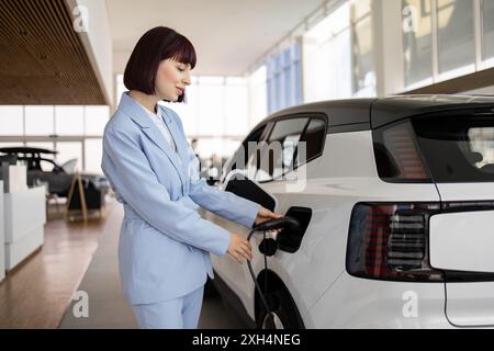 Geschäftsfrau kauft elektrischen SUV im Autohaus Stockfoto