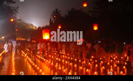 Eine große Gruppe buddhistischer Menschen im Tempel von Borobudur, die brennende Kerzen und Laternen halten. Die Szene wird mit warmem, einladendem Licht, Kreatin beleuchtet Stockfoto