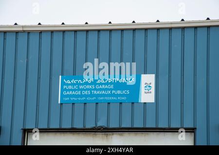 Mehrsprachiges Schild für öffentliche Arbeiten auf Englisch, Französisch und Inuktitut an der Federal Road in Iqaluit, Nunavut, Kanada Stockfoto