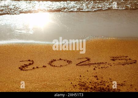 Meer Sonnenaufgang des ersten neuen Tages für 2025 Jahre Text auf Strand Sand Stockfoto