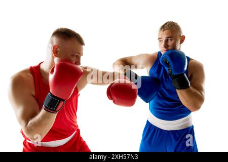 Zwei Athleten, die im Kickboxspiel teilnahmen, wobei ein roter Kämpfer einen blau gekleideten Gegner vor weißem Studiohintergrund herausfordert. Stockfoto