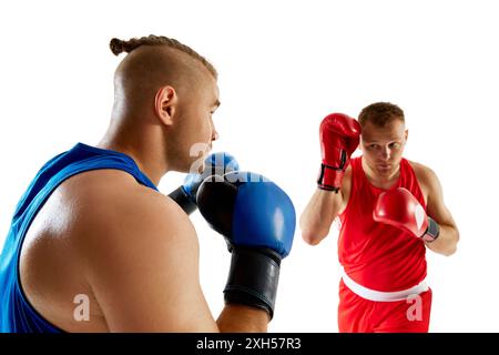 Zwei Kampfsportler, die an einem Sparring teilnahmen, ein roter Wettkämpfer gegen einen blauen Wettkämpfer vor weißem Studiohintergrund. Stockfoto