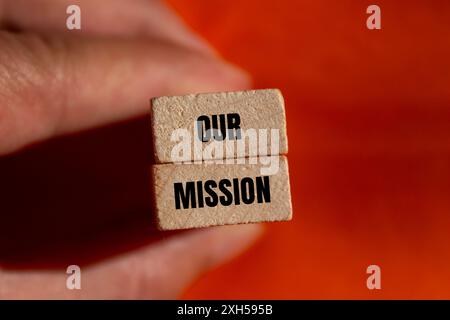 Unsere Botschaft auf Holzblöcken mit orangefarbenem Hintergrund. Konzeptionelles unser Missionssymbol. Kopierbereich. Stockfoto