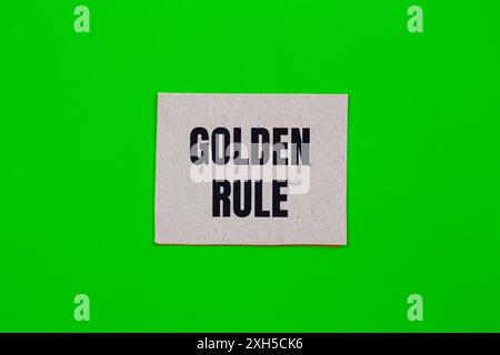 Goldene Regel-Nachricht auf Papier mit grünem Hintergrund geschrieben. Konzeptionelles goldenes Regelsymbol. Kopierbereich. Stockfoto