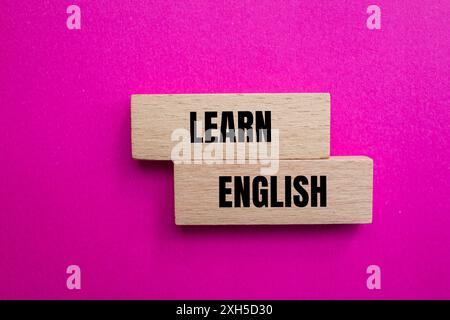 Lernen Sie englisch Nachricht geschrieben auf Wodoen Blöcken mit rosa Hintergrund. Symbol für konzeptuelles Lernen englisch. Kopierbereich. Stockfoto