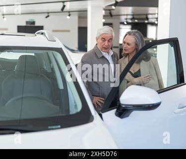 Ein älteres kaukasisches Paar wählt ein neues Auto in einem Autohändler. Stockfoto