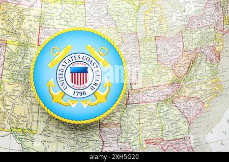 KIEW, UKRAINE - 26. JUNI 2024 Wappen der US-Küstenwache auf Papierkarte der Vereinigten Staaten von Amerika Stockfoto