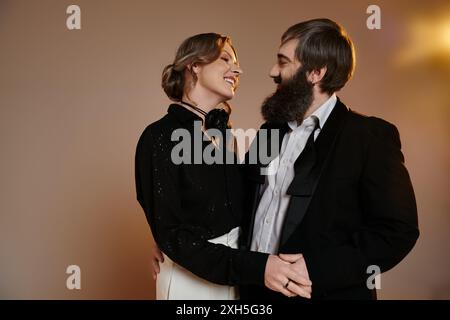 Ein Paar in formeller Kleidung schaut sich liebevoll in einem Studio an. Stockfoto