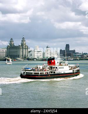 Die Liverpool Fähre überqueren den Fluss Mersey mit den drei Grazien Pier Head Gebäuden hinter. Merseyside, England, Vereinigtes Königreich. Stockfoto