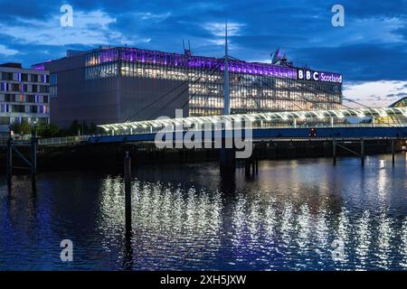 Abend im BBC Scotland Building und der Bell's Bridge über den Fluss Clyde mit glitzernder Reflexion im Wasser, TV- und Radiostudio-Komplex in Paci Stockfoto