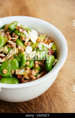 Hausgemachte cremige Buchweizen- und Favabohnensalat mit Haselnüssen und sonnengetrockneten Tomaten. Stockfoto