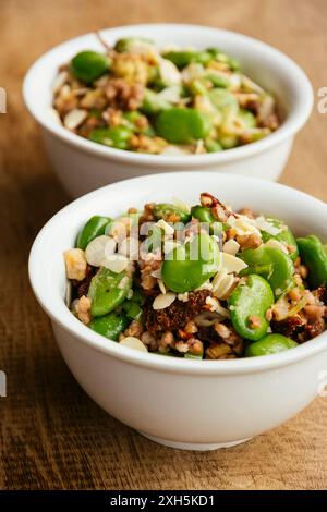 Hausgemachte cremige Buchweizen- und Favabohnensalat mit Haselnüssen und sonnengetrockneten Tomaten. Stockfoto