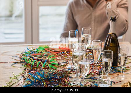 Feiern Sie eine Veranstaltung mit Sekt und Sektgläsern auf einem Tisch mit Konfetti Stockfoto