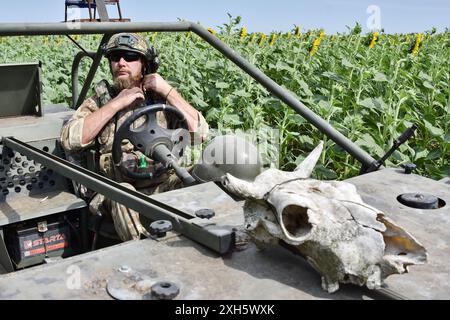 Ein ukrainischer Soldat aus dem Evakuierungsteam der 65. Separaten Mechanisierten Brigade zieht einen Helm an, während er im Evakuierungswagen in der Nähe von Orichhiv sitzt. Ukrainische Verteidiger benutzen Strandbuggys, Geländefahrzeuge und Elektrofahrräder an der Front, da diese Fahrzeuge leiser und schwieriger zu sehen und zu hören sind. Dies gibt Soldaten an der Front eine bessere Chance, russischen Drohnen zu entgehen und zu überleben. Diese kleinen Fahrzeuge waren kein Ersatz für traditionelle Militärfahrzeuge. Ihnen fehlt die Feuerkraft und der Platz, um eine große Anzahl von Menschen oder Fracht zu transportieren, und ihr Mangel an Rüstung lässt alles übrig Stockfoto