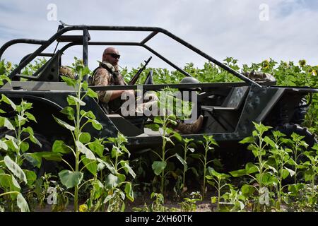 Ein ukrainischer Soldat aus dem Evakuierungsteam der 65. Separaten Mechanisierten Brigade sitzt im Evakuierungswagen bei Orichhiv. Ukrainische Verteidiger benutzen Strandbuggys, Geländefahrzeuge und Elektrofahrräder an der Front, da diese Fahrzeuge leiser und schwieriger zu sehen und zu hören sind. Dies gibt Soldaten an der Front eine bessere Chance, russischen Drohnen zu entgehen und zu überleben. Diese kleinen Fahrzeuge waren kein Ersatz für traditionelle Militärfahrzeuge. Sie verfügen nicht über die Feuerkraft und den Platz, um eine große Anzahl von Personen oder Fracht zu transportieren, und ihr Mangel an Rüstung macht alle an Bord verwundbar. Bu Stockfoto